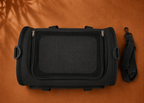 Vue du dessus d'un sac de transport pour chat noir avec poignée et sangle.